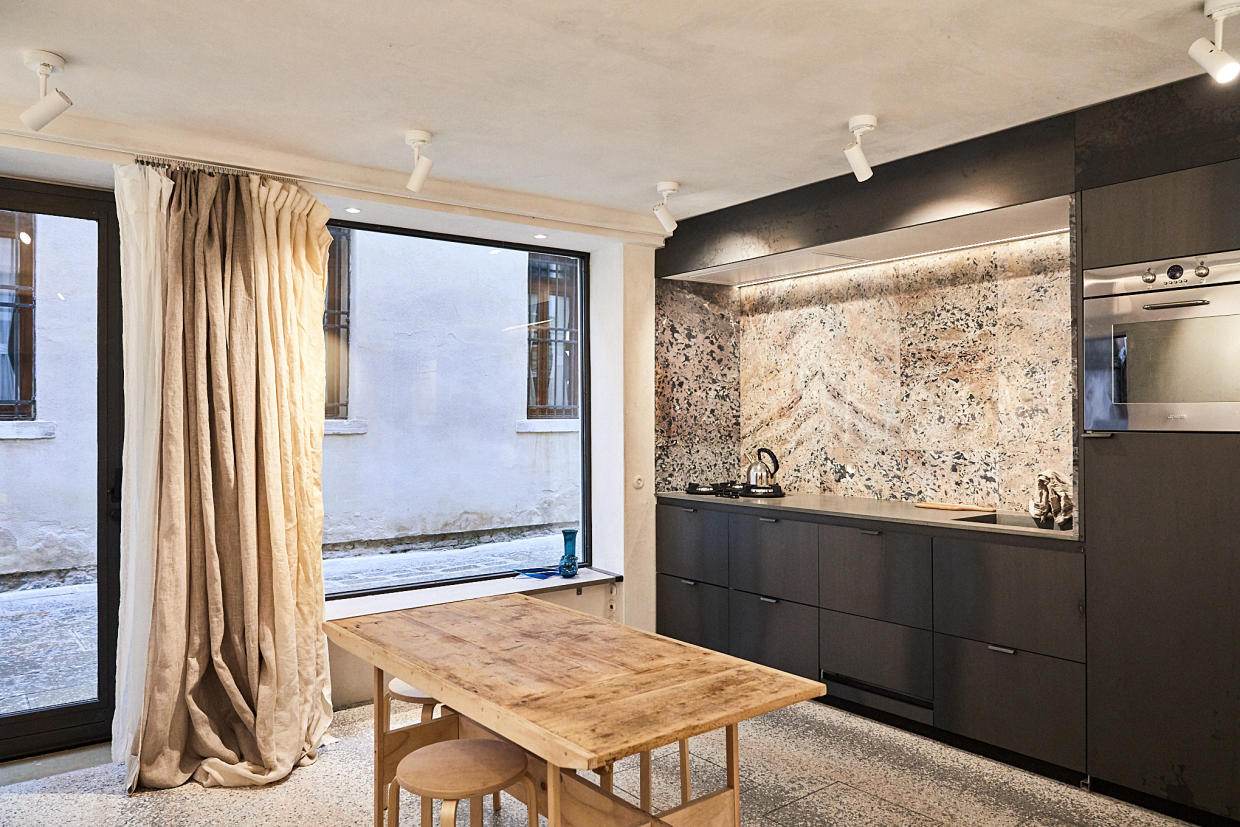 Kitchen with recuperated marble from an ancient Abbey near St Marc's Square. When the kitchen counter is covered the space transforms into a gallery. Photo by Paulina Westerlind.