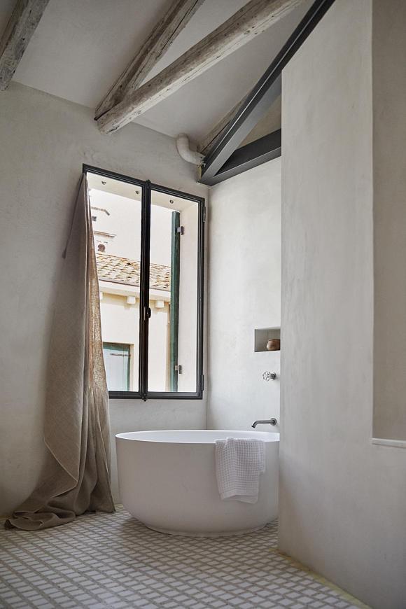 StudioGiardini's master bedroom and bathroom with a triangular shower and a round bathtub. Photo by Paulina Westerlind